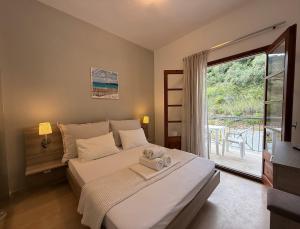 a bedroom with a bed and a large window at Theros Apartments in Mola Kalyva