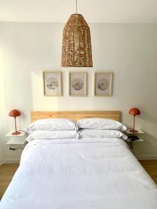 ein Schlafzimmer mit einem großen weißen Bett mit zwei Lampen in der Unterkunft BERENGUER HUESCA con parking in Huesca