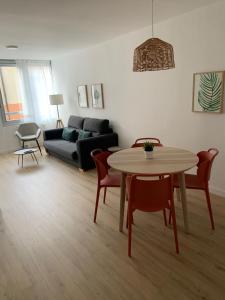 ein Wohnzimmer mit Tisch und Stühlen und einer Couch in der Unterkunft BERENGUER HUESCA con parking in Huesca