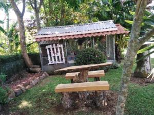 a wooden bench in front of a small house at Bromelias in Tambor