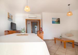 un salon avec une table blanche et un canapé dans l'établissement Apt Baleeira Sol, à Albufeira