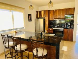 a kitchen with a black counter top and wooden cabinets at Spacious and luxurious Yumil Condominium 137m2 in Los Barriles