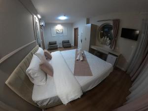 a hotel room with a large bed with white sheets at Villa Royal Apartments in Bitola