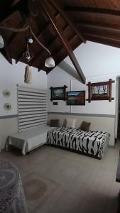 una camera con un letto bianco e nero di CASA TODA EN PLANTA BAJA CON PARQUE y PILETA INDIVIDUAL SOBRE ASFALTO A POCAS CUADRAS DEL CENTRO DE MERLO a Merlo