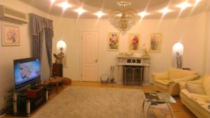 a living room with a couch and a tv at All Apartments City in Dnipro