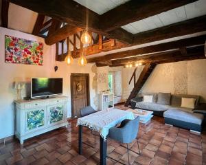 a living room with a couch and a tv at Petite maison du causse in Salles-la-Source