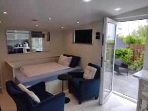 a bedroom with a bed and two chairs and a television at Villa Baneheia-Studios & Apartment in Kristiansand