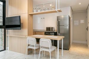 a kitchen with a table and a refrigerator at Piscina com Vista Mar | WI-FI 200mb #CAC01 in Florianópolis