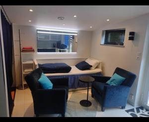 a living room with a bed and two chairs at Villa Baneheia-Studios & Apartment in Kristiansand +23 photos