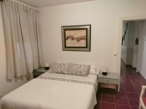 マラガにあるFantástico apartamento con piscina comunitaria junto al mar en Málagaのベッドと壁に絵が飾られた寝室
