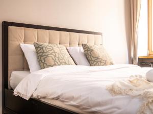 a large bed with white sheets and pillows at Old Riga 1BR, Doma Square Views in Rīga