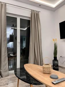 Habitación con mesa y sala de estar con sofá. en Kyklamino Apartment, en Loutra Oraias Elenis
