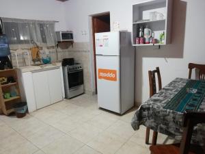 a kitchen with a white refrigerator and a table at Acuario Departamentos in Presidencia Roque Sáenz Peña