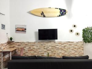 deskę surfingową wiszącą na ścianie salonu w obiekcie Apartamento Mar del norte, en Cotillo. w mieście Cotillo