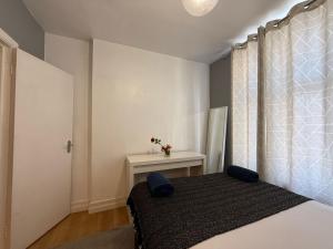 a bedroom with a bed and a window with a table at A3-1st Floor 2 Bed Flat near Elephant and Castle in London