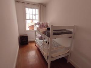 ein kleines Zimmer mit einem Etagenbett und einem Fenster in der Unterkunft Hostel SP&Bed in São Paulo