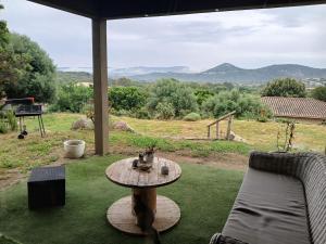a patio with a table and a couch and a view at T4 Villa SOTTA entre mer et montagnes in Sotta