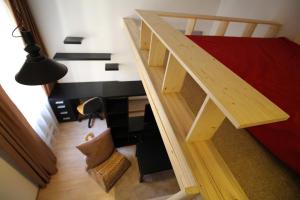 a loft bed with a desk in a room at Giedres Old town studio in Kaunas