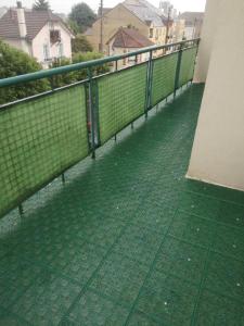 a green fence on the side of a building at Appartement Argenteuil avec Terrasse in Argenteuil
