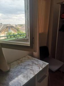 a room with a window with a view of a balcony at Appartement Argenteuil avec Terrasse in Argenteuil +2 photos