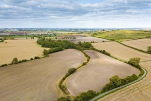 an aerial view of a golf course with fields and trees at Willow Lodge In Hexton in Hexton +6 photos