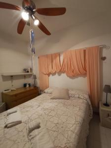 a bedroom with a bed with a ceiling fan at CASA CELESTE in San Nicola Arcella
