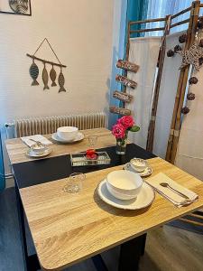 un tavolo con piatti e piatti sopra di Appart moderne REVE BLEU Hypercentre Blois à 5 min Château a Blois