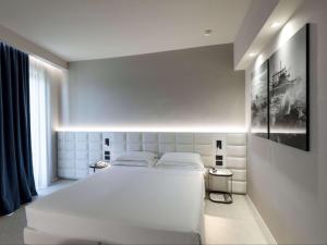 a white bedroom with a large white bed in it at Hotel Cristallo in Giulianova