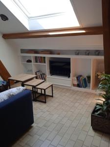 a skylight in a living room with a table and a tv at Les Roses de Rita in Boisset-lès-Montrond