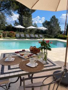 a table with food on it next to a pool at Villa Taradis in Taradeau