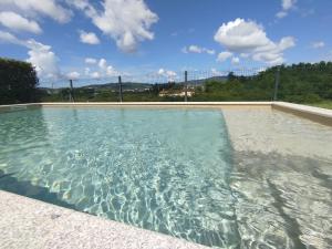 a swimming pool with clear blue water at Balutinha's house in Barcelos