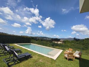 a swimming pool with lawn chairs at Balutinha's house in Barcelos