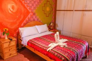 een slaapkamer met een bed met een knuffeldier erop bij OtavaloHuasi2 Quito in Quito