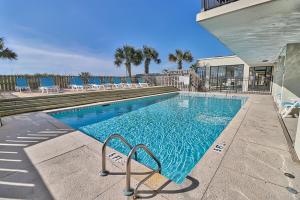 a swimming pool with blue chairs and a building at Oceanfront Waterpointe 1 Unit 803 3 bedroom 2 bath Balcony Pools in North Myrtle Beach