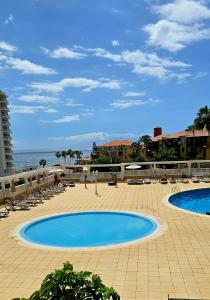 a large swimming pool next to the ocean at Las Americas Blue Ocean Apartment in Costa de Adeje