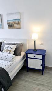 a bedroom with a bed with a blue nightstand and a lamp at Las Americas Blue Ocean Apartment in Costa de Adeje +23 photos