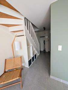 un escalier avec une chaise en bois dans la chambre dans l'établissement Le cottage du moulin - NETFLIX - WiFi - Garage, à Oresmaux