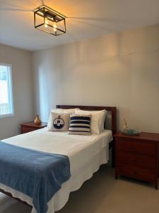 Apartamento Alto Padrão في غوارويا: غرفة نوم بها سرير كبير وثريا +59 صورة