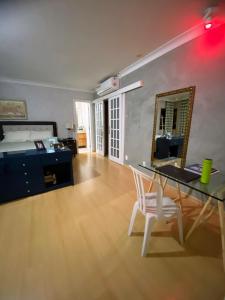 ein Schlafzimmer mit einem Schreibtisch, einem Bett und einem Spiegel in der Unterkunft Casa bela in Lauro de Freitas