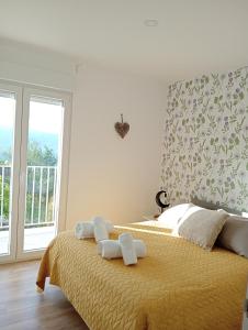 a bedroom with a bed with two towels on it at Casa Coruja in Ponte da Barca