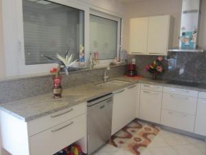 a kitchen with white cabinets and a counter top at Viva B&B in Anavyssos