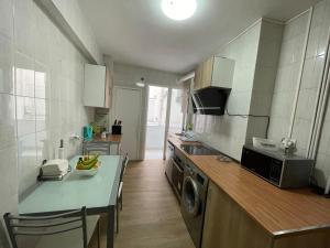a kitchen with a sink and a table with a microwave at El Bierzo - Ponferrada in Ponferrada
