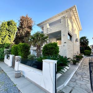a house with a white fence in front of it at Marko's Place in Hanioti