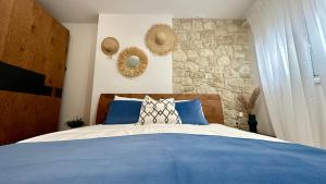 a bedroom with a blue bed and a stone wall at Marko's Place in Hanioti