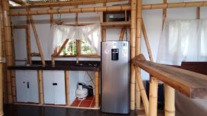 a kitchen with a refrigerator in the middle of a room at Hospedaje Rural La Trinchera Mirador a la montañas Cerro Azul Trujillo in Trujillo