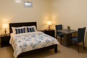 NgorChambre meublée à Ngor dans une zone calme et accessible的一间卧室配有一张床、一张桌子和两把椅子