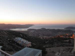 a view of a city and the ocean at sunset at Viva B&B in Anavyssos