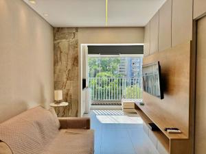 a living room with a couch and a television at Edição Jardim Paulista in Sao Paulo