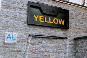 a black and yellow sign on the side of a building at Dark Yellow in Ponta do Sol
