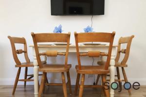 une table de salle à manger avec deux chaises et une télévision dans l'établissement Seaside cottage close to beach, à Pakefield